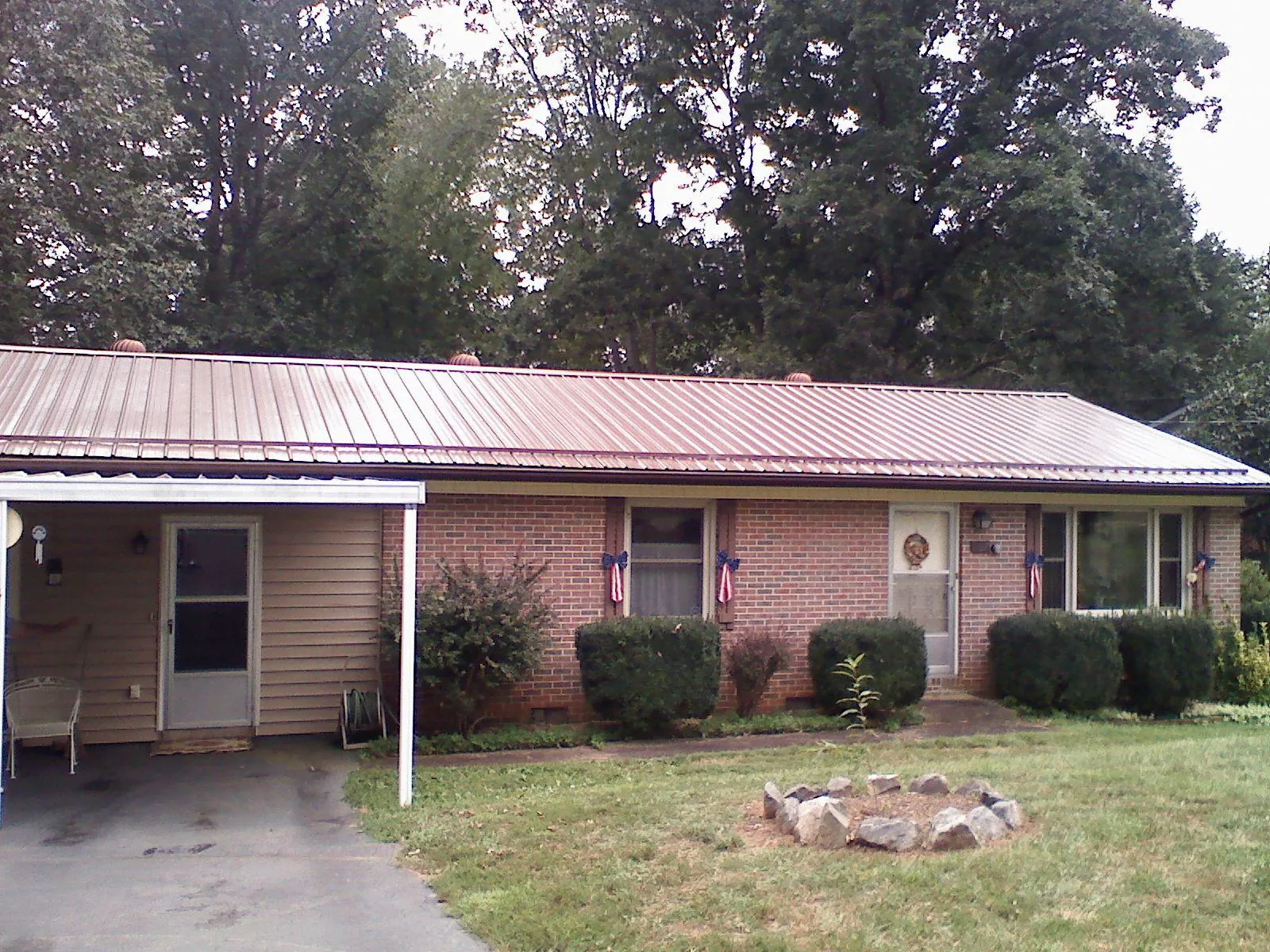 Bronze metal roof and carport on a brick ranch home — Roof Repair work by our crew in Changewater